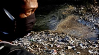 Warga melihat aliran sungai Cileungsi yang tercemar limbah di Bojong Kulur, Gunung Putri, Kabupaten Bogor, Jawa Barat, Senin (27/7/2020). [ANTARA FOTO/Yulius Satria Wijaya]