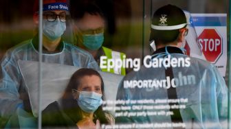 Petugas memindahkan seorang penduduk dari fasilitas perawatan lansia Epping Gardens di pinggiran kota Melbourne, Australia,  Selasa (28/7/2020).  [William WEST / AFP]