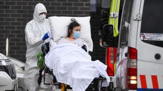 Petugas ambulan memindahkan seorang penduduk dari fasilitas perawatan lansia Epping Gardens di pinggiran kota Melbourne, Australia,  Selasa (28/7/2020).  [William WEST / AFP]