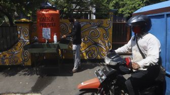 Warga mencuci tangan di kampung Siaga COVID-19 di Kampung Rawa Pasung RW 22, Kota Baru, Kota Bekasi, Jawa Barat, Selasa (28/7/2020). [Suara.com/Angga Budhiyanto]