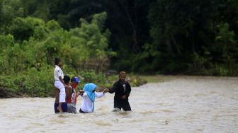 Tak Ada Listrik dan Internet, Guru Menyeberang Sungai Demi Mengajar