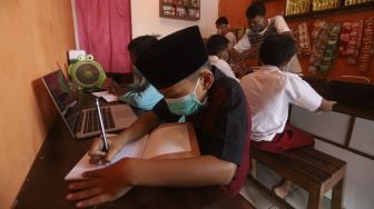 Siswa belajar secara online di Warkop Rizki, Pondok Aren, Tangerang Selatan, Banten, Rabu (29/7/2020). [Suara.com/Angga Budhiyanto]