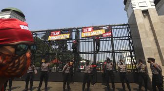 Sejumlah massa buruh yang tergabung dalam Konfederasi Serikat Pekerja Indonesia ( KSPI) memasang spanduk saat mengelar aksi unjuk rasa di depan Gedung DPR, Jakarta, Rabu (29/7/2020). [Suara.com/Angga Budhiyanto]