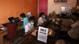 Siswa belajar secara online di Warkop Rizki, Pondok Aren, Tangerang Selatan, Banten, Rabu (29/7/2020). [Suara.com/Angga Budhiyanto]