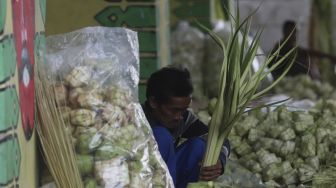 Pedagang menyelesaikan pembuatan kulit ketupat di bawah jalan tol di kawasan Bintaro, Jakarta, Kamis (30/7/2020). [Suara.com/Angga Budhiyanto]