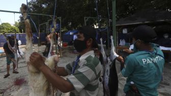 Petugas memotong daging kurban di lingkungan Masjid Al-Azhar, Jakarta, Jumat (31/7/2020). [Suara.com/Angga Budhiyanto]