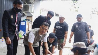 Pemilik PS Store Putra Siregar ikut memotong daging kurban saat pemecahan Rekor Muri pemotongan sebanyak 404 hewan kurban di Condet, Jakarta Timur, Jumat (31/7). [Suara.com/Alfian Winanto]