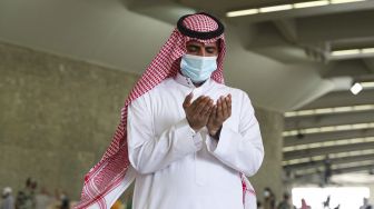 Jemaah haji berdoa usai melangsungkan lontar jumrah dengan mengenakan masker wajah untuk menghindari penularan COVID-19 di Mina, Arab Saudi, Sabtu (1/8/2020). [AFP]