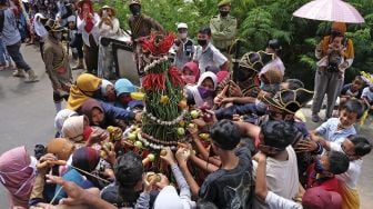 Sejumlah warga berebut Gunungan Palawija saat tradisi Grebeg Besar Lamuk Legok di lereng Gunung Sumbing Desa Legoksari, Tlogomulyo, Temanggung, Jawa Tengah, Minggu (2/8/2020). [ANTARA FOTO/Anis Efizudin]