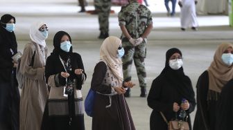 Sejumlah jemaah haji tiba untuk melangsungkan lontar jumrah dengan mengenakan masker wajah untuk menghindari penularan COVID-19 di Mina, Arab Saudi, Sabtu (1/8/2020). [AFP]