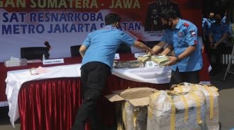 Anggota Ditresnarkoba Polres Metro Jakarta Selatan menyiapkan barang bukti narkoba saat menggelar konferensi pers kasus narkoba jaringan lintas Sumatera-Jawa di halaman Polres Metro Jakarta Selatan, Senin (3/8/2020). [Suara.com/Angga Budhiyanto]