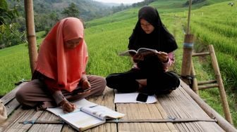 Siswa SMA mengikuti kegiatan belajar mengajar dalam jaringan (daring) di area persawahan Bassaran, Desa Rante Mario, Kabupaten Enrekang, Sulawesi Selatan, Senin (3/8/2020).   [ANTARA FOTO/Arnas Padda]