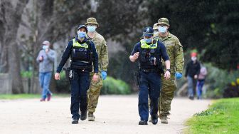 Petugas kepolisian bersama tentara melakukan patroli di Melbourne, Australia, Selasa (4/8).  [AFP/William WEST]