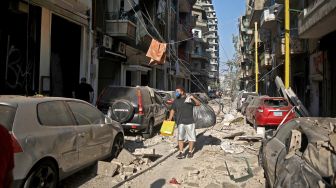 Warga berdiri ditengah bangunan gedung yang hancur  setelah ledakan besar di wilayah pelabuhan Beirut, Lebanon, Selasa (5/8/2020). [Foto/AFP]