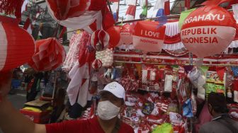 Seorang calon pembeli memilih pernak-pernik kemerdekaan di Pasar Jatinegara, Jakarta, Rabu (5/8/2020). [Suara.com/Angga Budhiyanto]