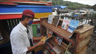 Warga memilih buku untuk dibaca di Taman Bacaan Masyarakat (TBM) Lentera Kota Tua, di tepian sungai Batang Arau, Padang, Sumatera Barat, Rabu (5/8/2020). [ANTARA FOTO/Iggoy el Fitra]