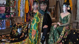 Model mengenakan pelindung wajah melakukan peragaan busana pengantin tradisional bermotif batik di Surabaya, Jawa Timur, Kamis (6/8/2020).  [FOTO/Zabur Karuru]