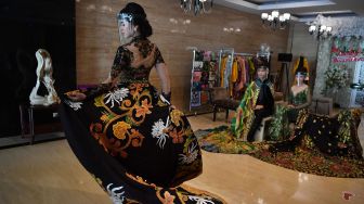 Model wanita mengenakan pelindung wajah melakukan peragaan busana pengantin tradisional bermotif batik di Surabaya, Jawa Timur, Kamis (6/8/2020).  [FOTO/Zabur Karuru]