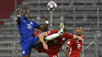 Striker Chelsea Tammy Abraham (kiri) bertarung memperebutkan bola dengan gelandang Bayern Munich Leon Goretzka selama pertandingan  babak 16 besar Liga Champions UEFA antara FC Bayern Munich melawan Chelsea di Munich, Jerman, Sabtu (8/8/2020). [Tobias SCHWARZ / AFP]