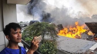 Warga mengamati kebakaran di pabrik mebel di kawasan Cakung, Jakarta Timur, Minggu (9/8/2020). [ANTARA FOTO/ Fakhri Hermansyah]