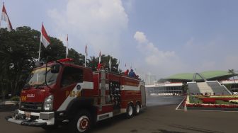 Petugas pemadam kebakaran menyemprotkan cairan disinfektan di area komplek Gedung DPR/MPR RI, Jakarta, Minggu (9/8/2020). [Suara.com/Angga Budhiyanto]