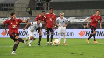 Gelandang Manchester United Bruno Fernandes mencetak gol melalui penalti selama pertandingan sepak bola perempat final Liga Europa antara Manchester United melawan Copenhagen di RheinEnergieStadion stadium, Selasa (11/8/2020) dini hari WIB. [RATTAY WOLFGANG / POOL / AFP]
