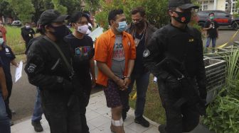 Tersangka Alfiyan memperagakan reka ulang pembunuhan WN Taiwan, Hsu Ming Hu di Tempat Kejadian Perkara (TKP) di Cikarang, Kabupaten Bekasi, Jawa Barat, Kamis (13/8/2020). [Suara.com/Angga Budhiyanto]