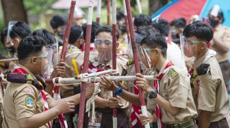 Sejumlah siswa mendirikan gapura bambu dalam perkemahan Hari Pramuka di Bumi Perkemahan Pramuka, Cibubur, Jakarta, Jumat (14/8/2020). [ANTARA FOTO/Aditya Pradana Putra]