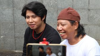 Ekspresi Komedian Mastur dan putranya Ahmad Syaiful saat menjawab pertanyaan awak media di Kawasan Tendean, Jakarta Selatan, Jumat (14/8). [Suara.com/Alfian Winanto]