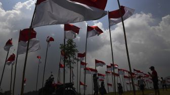 Pengunjung berfoto di antara bendera Merah Putih yang dipasang di Poetoek Suko, Trawas, Mojokerto, Jawa Timur, Minggu (16/8/2020). [ANTARA FOTO/Zabur Karuru]