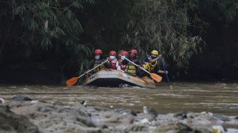 Petugas upacara menaiki perahu karet saat melaksanakan upacara bendera di Sungai Ciliwung, GDC, Depok, Jawa Barat, Senin (17/8/2020). [Suara.com/Angga Budhiyanto]