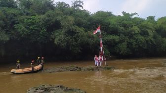 Warga Depok Gelar Upacara Kemerdekaan di Tengah Derasnya Sungai Ciliwung