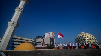 Sejumlah pengurus Dewan Kemakmuran Masjid (DKM) mengarak bendera Merah Putih usai mengikuti upacara peringatan kemerdekaan Republik Indonesia di atap Masjid Raya Bandung, Jawa Barat, Senin (17/8/2020).  [ANTARA FOTO/Raisan Al Farisi]