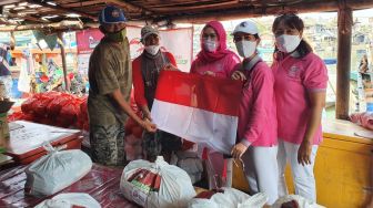 Perempuan Indonesia Maju Bagikan Bendera Merah Putih dan Bantuan Sosial