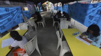 Sejumlah siswa belajar secara online di tenda wifi gratis di taman warga RT 013, Pondok Kelapa, Jakarta Timur, Selasa (18/8/2020). [Suara.com/Angga Budhiyanto]