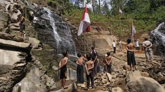 Sejumlah warga mengikuti upacara bendera di Curug Tarung kawasan lereng gunung Prahu Dusun Gunung Wuluh, Canggal, Candiroto, Temanggung, Jawa Tengah, Selasa (18/8/2020). [ANTARA FOTO/Anis Efizudin]