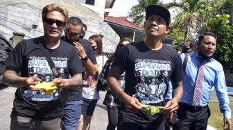 Personel Superman is Dead (SID) Bobby Kool (kedua kanan) dan Eka Rock (kiri) tiba di Polda Bali, Denpasar, Bali, Selasa (18/8/2020). [ANTARA FOTO/Fikri Yusuf]