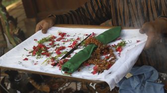 Nasip Hadi Prayitno (51) menerima pusaka berupa mata tombak saat melakukan ritual jamasan di Museum Pusaka Taman Mini Indonesia Indah (TMII), Jakarta, Kamis (20/8/2020). [Suara.com/Angga Budhiyanto]