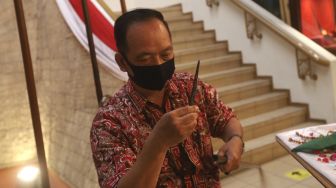 Petugas museum memindahkan pusaka berupa mata tombak saat melakukan ritual jamasan di Museum Pusaka Taman Mini Indonesia Indah (TMII), Jakarta, Kamis (20/8/2020). [Suara.com/Angga Budhiyanto]