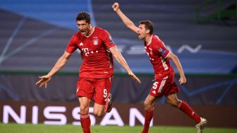 Penyerang Bayern Muenchen Robert Lewandowski (kiri) merayakan golnya dengan penyerang Jerman Bayern Munich Thomas Mueller setelah mencetak gol selama  selama pertandingan sepak bola semifinal Liga Champions antara Lyon melawan Bayern Muenchen di Stadion Jose Alvalade, Lisbon, Portugal, Kamis (20/8/2020) dini hari WIB. [Miguel A. Lopes / POOL / AFP]