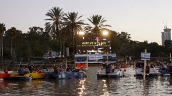 Sejumlah warga Israel menonton film "Paddington" sambil duduk di perahu pedal di bioskop terapung Sail-in di Taman Hayarkon Tel Aviv, Israel, (20/8/2020). [JACK GUEZ / AFP]