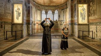 Seorang pendeta bersama dengan seorang perempuan mengunjungi Museum Chora atau Kariye di Istanbul, Jumat (21/8/2020). [BULENT KILIC / AFP]