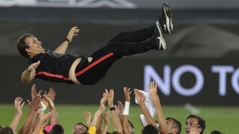 Para pemain Sevilla melempar pelatih Sevilla Spanyol Julen Lopetegui ke udara setelah pertandingan final Liga Eropa UEFA Sevilla melawan Inter Milan di RheinEnergieStadion, Cologne, Jerman pada (21/8/2020). [Friedemann Vogel / POOL / AFP]