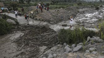 Warga membersihkan material lahar dingin di Desa Gurukinayan, Kabupaten Karo, Sumatera Utara, Sabtu (22/8/2020).  [ANTARA FOTO/Adiva Niki]