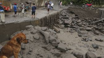 Warga membersihkan material lahar dingin di Desa Gurukinayan, Kabupaten Karo, Sumatera Utara, Sabtu (22/8/2020).  [ANTARA FOTO/Adiva Niki]