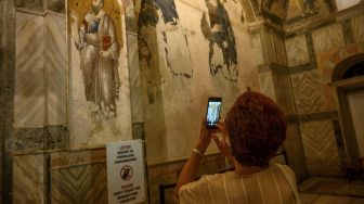 Seorang turis mengunjungi Museum Chora atau Kariye di Istanbul, Jumat (21/8/2020). [BULENT KILIC / AFP]