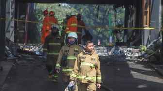 Petugas Damkar keluar usai melakukan proses pendinginan di gedung utama Kejaksaan Agung Republik Indonesia di Jalan Sultan Hasanuddin, Jakarta Selatan, Minggu (23/8). [Suara.com/Alfian Winanto]