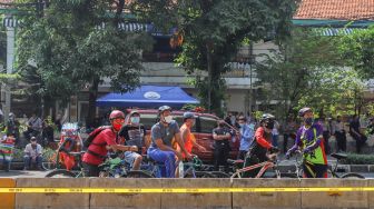 Warga melihat gedung utama Kejaksaan Agung RI yang habis terbakar saat bersepeda di Jalan Sultan Hasanuddin, Jakarta Selatan, Minggu (23/8). [Suara.com/Alfian Winanto]