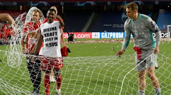 Kiper Bayern Munich, Manuel Neuer memotong gawang setelah pertandingan final Liga Champions antara Paris Saint-Germain melawan Bayern Munich di Luz stadium, Lisbon, Senin (24/8/2020) dini hari WIB. [LLUIS GENE / POOL]
