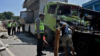 Petugas kepolisian mengevakuasi truk pengangkut susu kemasan yang terguling di Nagreg, Kabupaten Bandung, Jawa Barat, Selasa (25/8/2020). [ANTARA FOTO/Candra Yanuarsyah]
